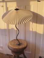Squiggle table lamp full silhouette against a neutral wall
