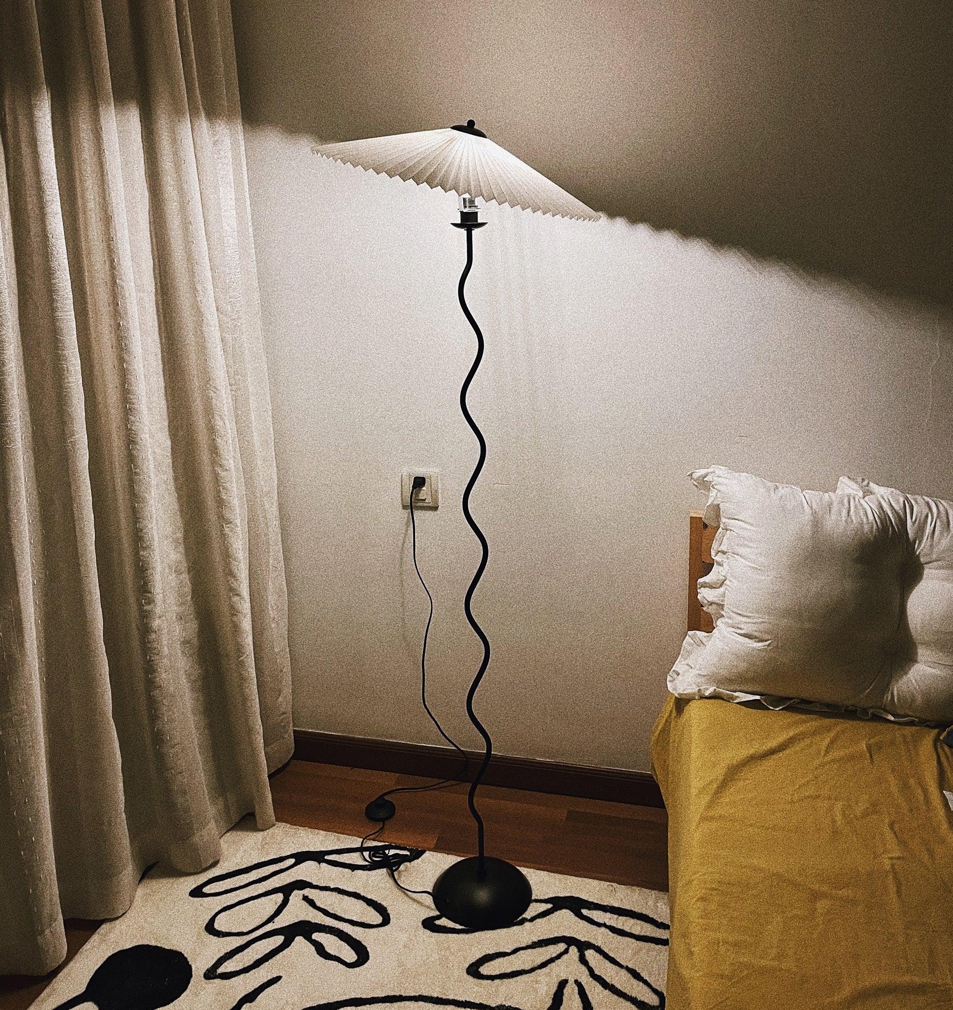 Squiggle floor lamp with wavy base in a styled bedroom