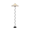 Squiggle floor lamp with wavy black base and fabric shade in a room corner