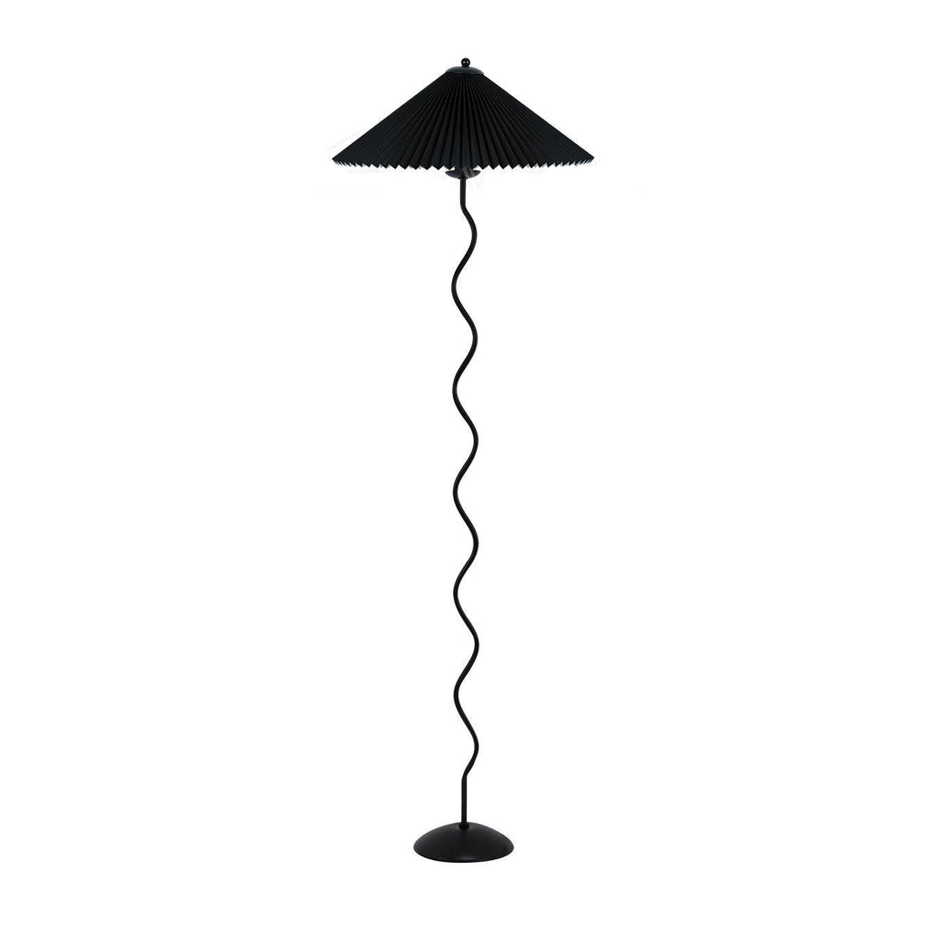 Squiggle floor lamp beside an armchair with warm glowing shade