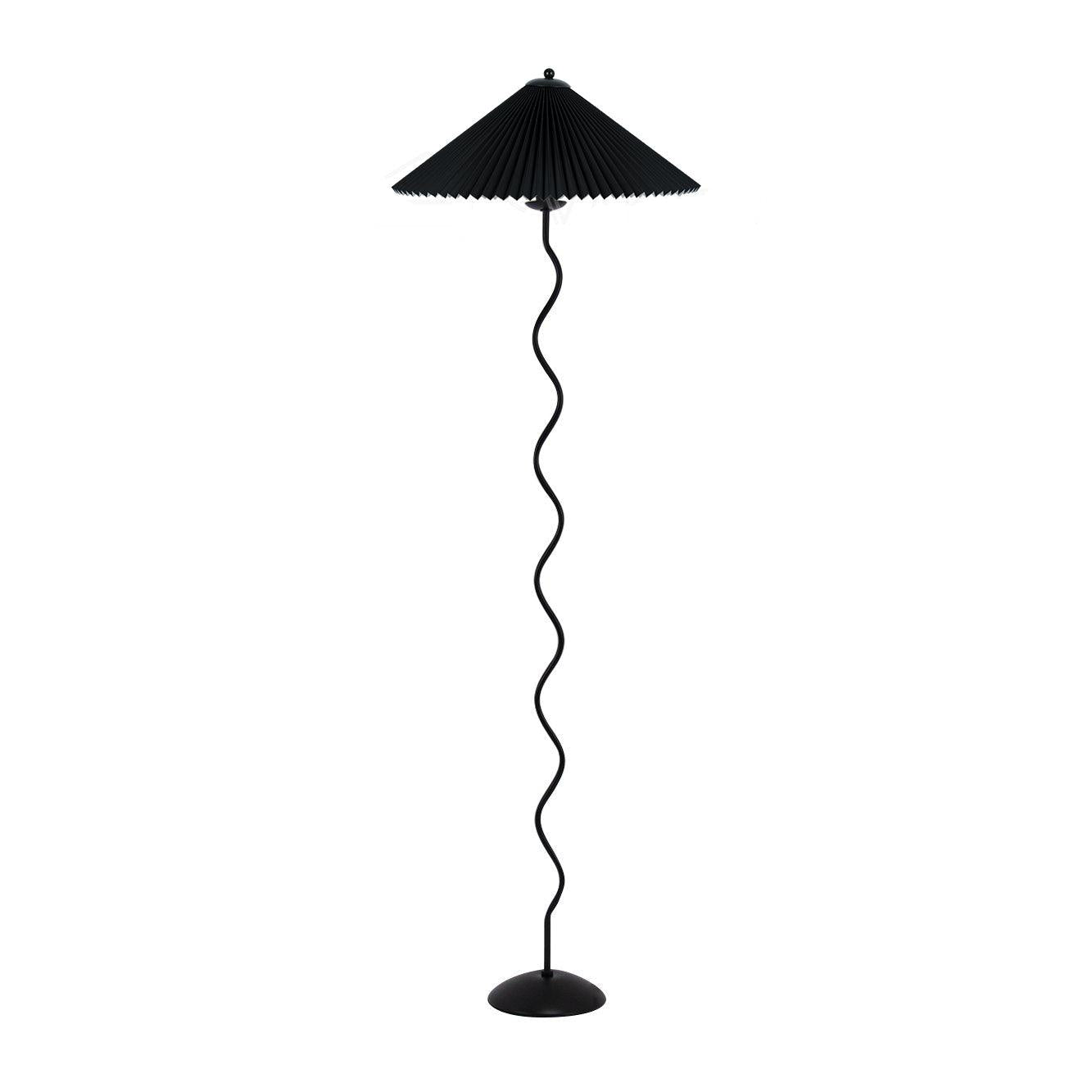 Squiggle floor lamp beside an armchair with warm glowing shade