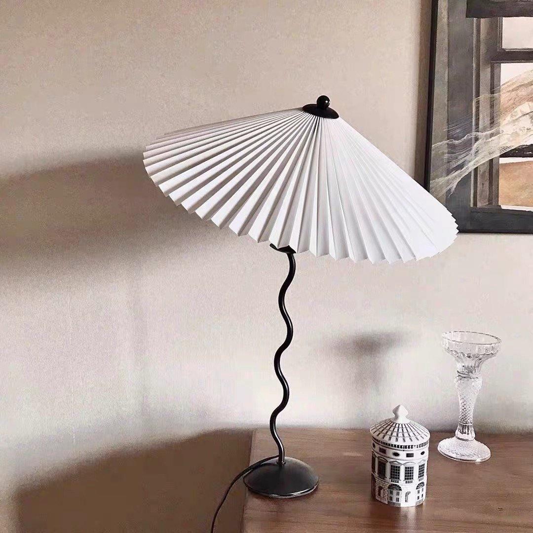 Squiggle table lamp glowing on a console in soft light