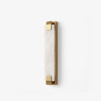 An angled studio view of this Clérachic panel sconce in brass finish, showing the metal clips that grip its panel.