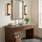This Clérachic panel sconce in black finish is lit beside a mirror above a concrete-top vanity with a vessel sink.