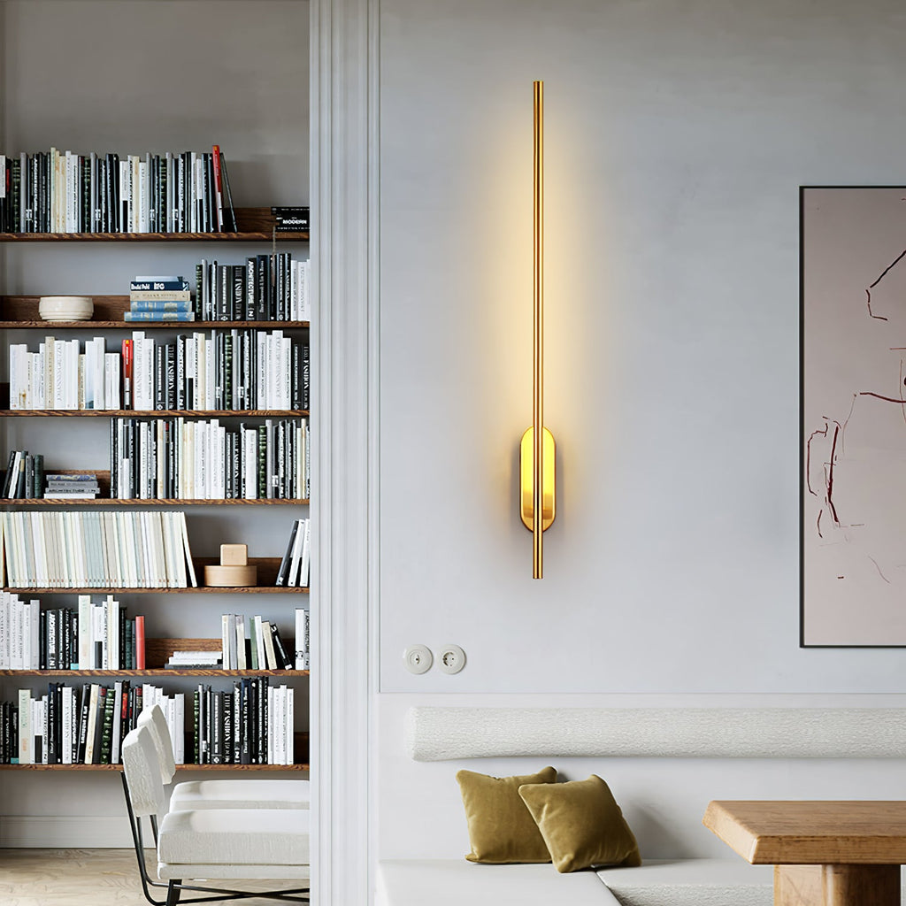 Slim linear sconce glowing against a dark feature wall