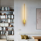 Slim linear sconce glowing against a dark feature wall