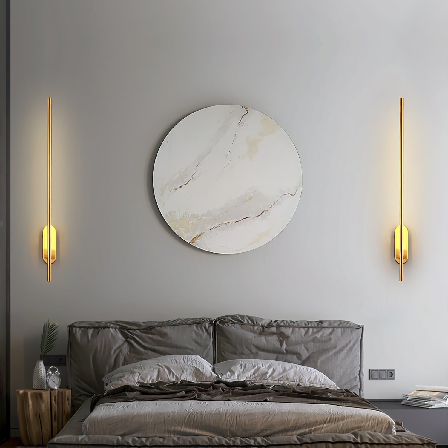 Stick-shaped wall sconce in black beside a bed for reading