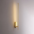 Linear metal wall sconce drawing a line of warm light up the wall