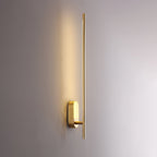 Linear metal wall sconce drawing a line of warm light up the wall