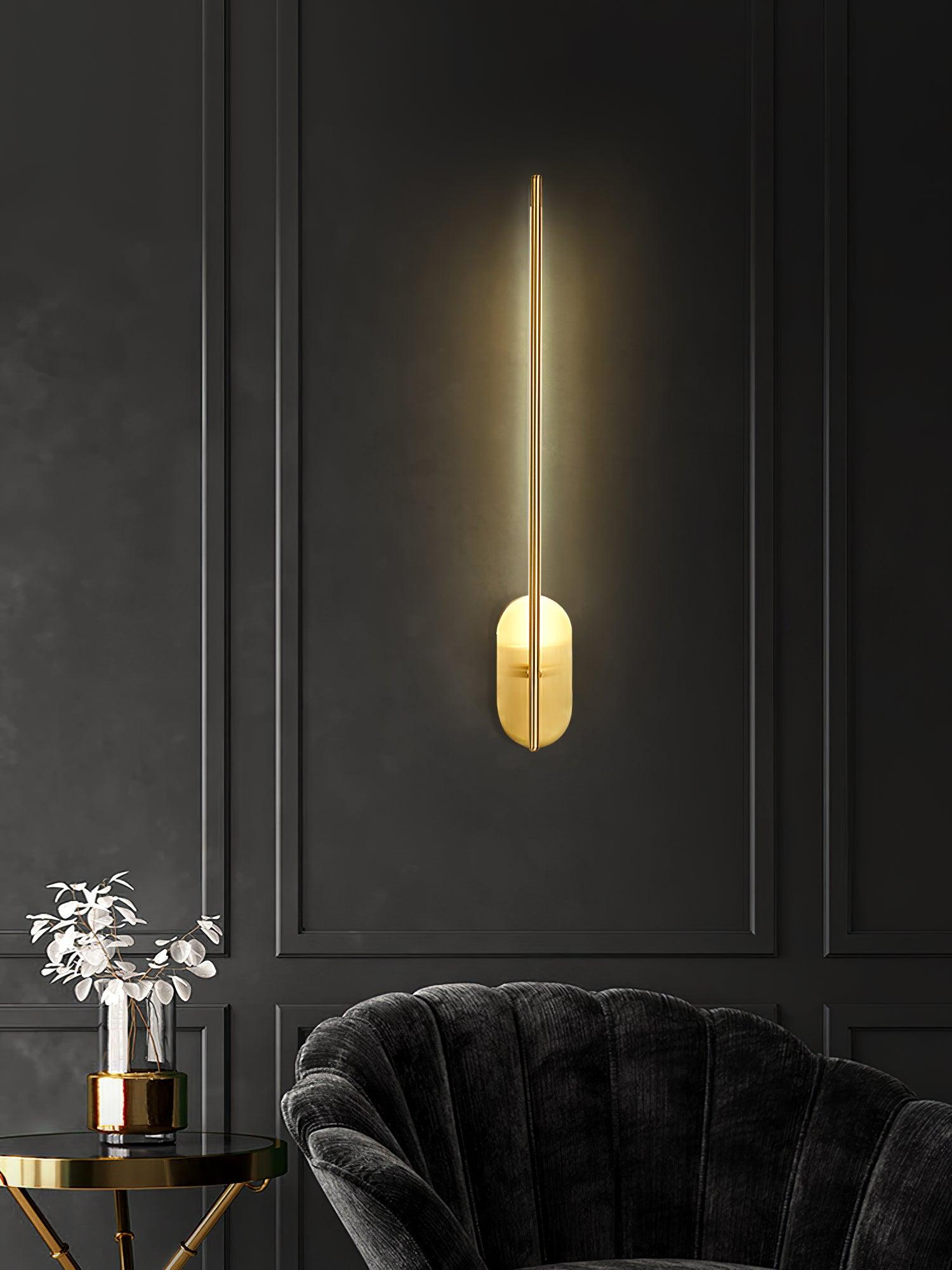 Black stick-shaped wall sconce with a soft vertical glow