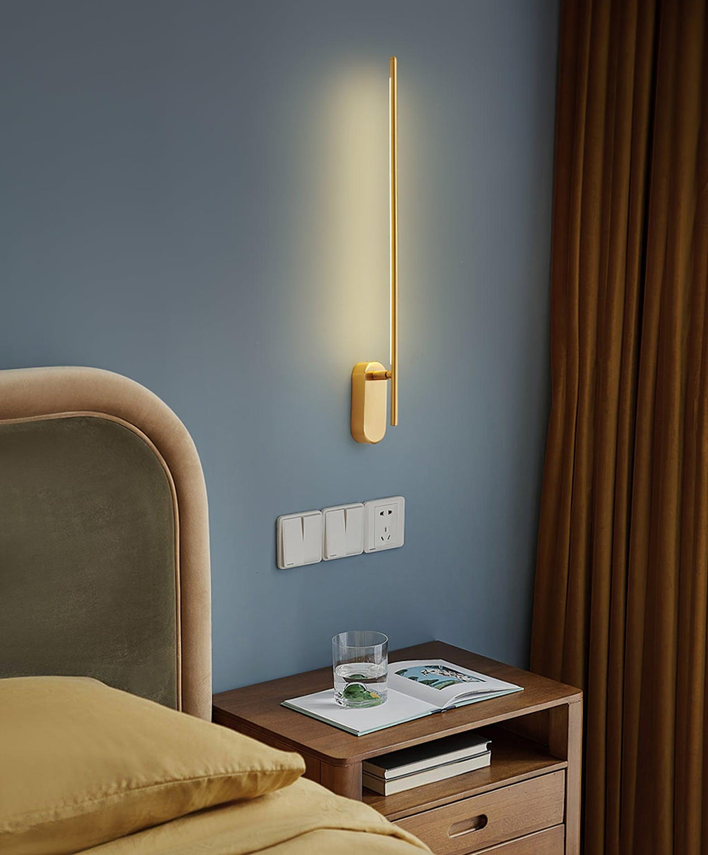 Slim wall sconce drawing a tall line of warm light