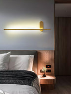 Stick-shaped metal sconce casting warm accent light