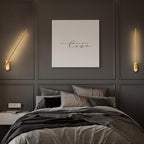 Linear metal wall sconce with soft vertical glow on a wall
