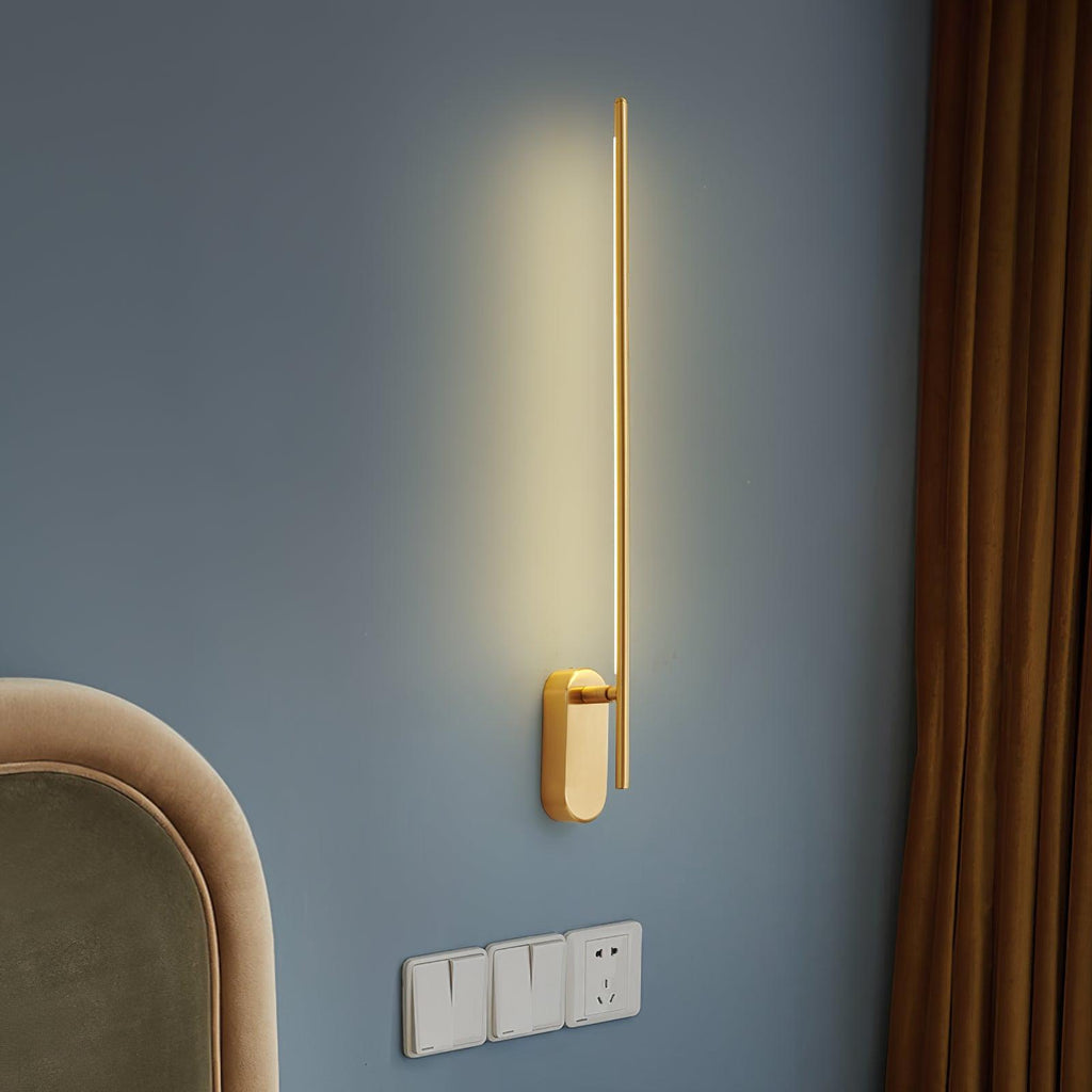 Linear metal sconce in black finish glowing in a hallway
