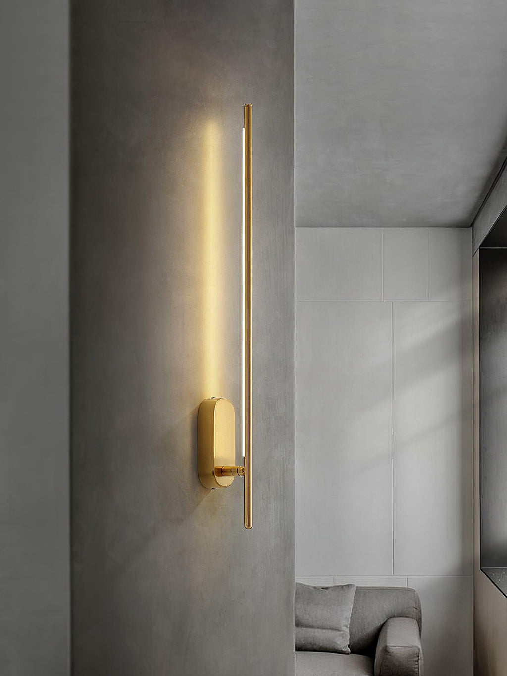 Stick-shaped wall sconce casting warm light in a bedroom