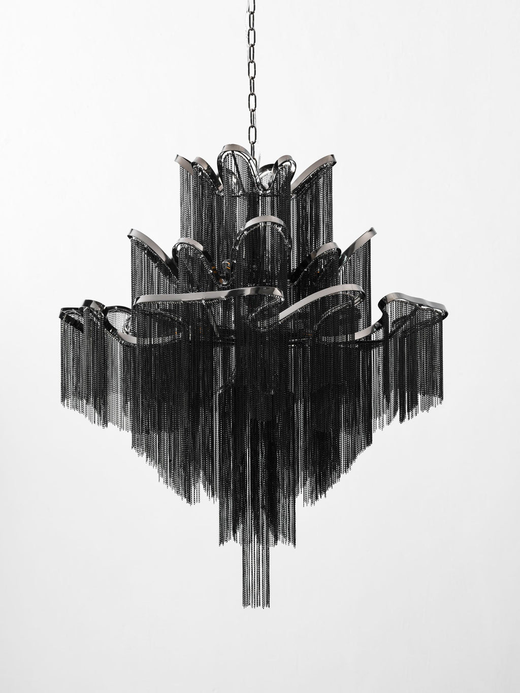 Seen from a slightly wider angle, this lit black Clérachic chandelier shows its full stepped tiers on white.