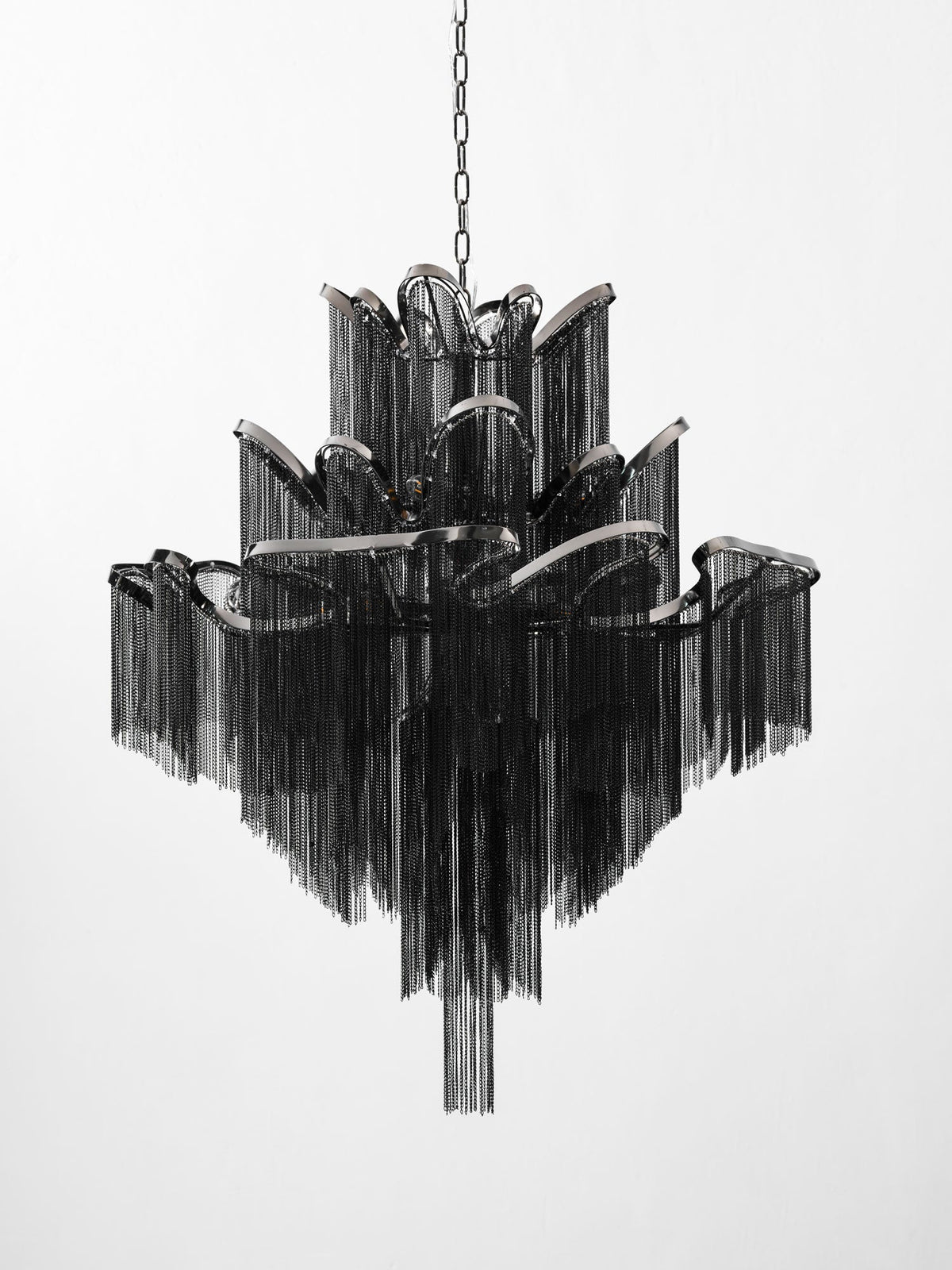 Seen from a slightly wider angle, this lit black Clérachic chandelier shows its full stepped tiers on white.