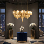 At night, this gold Clérachic chandelier lights a dim lounge flanked by potted orchids and a sculptural centrepiece.