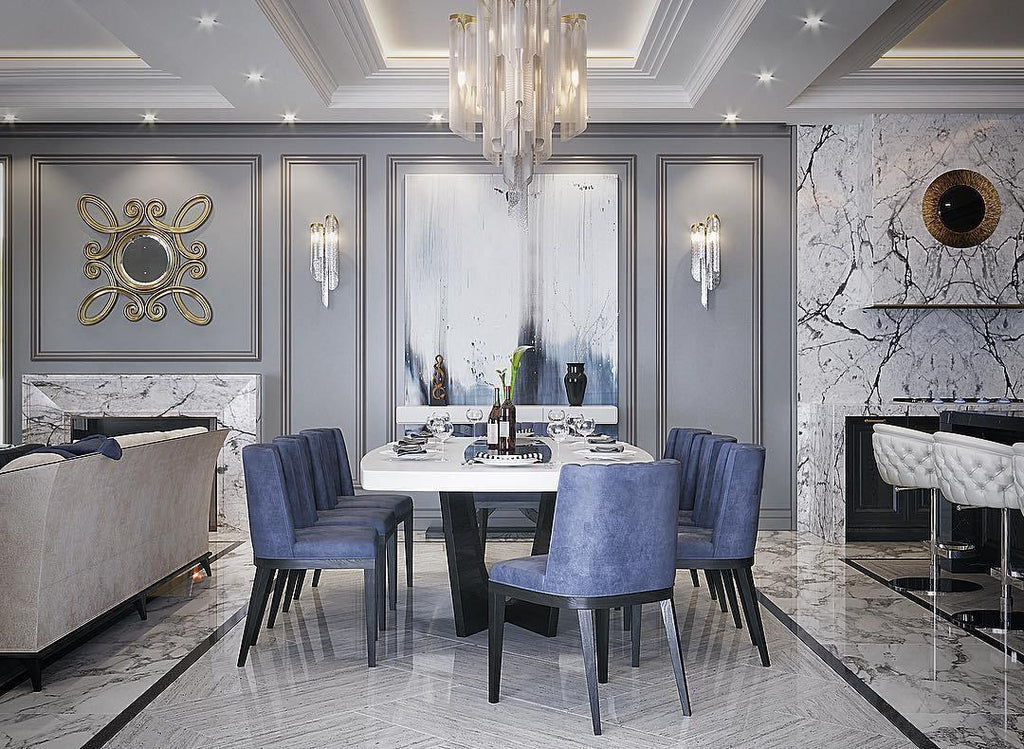 Blue upholstered chairs sit beneath this lit silver Clérachic chandelier in a formal dining room with a coffered ceiling.