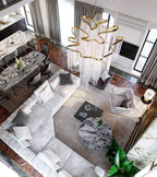 Viewed from above, this lit gold Clérachic chandelier's chain tiers form a wave-like shape over an open-plan lounge.