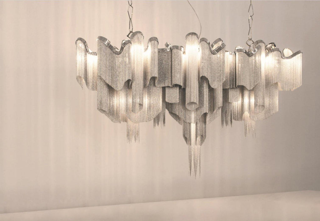 Against a warm plain backdrop, this lit silver Clérachic chandelier is shown with its tiers stepping outward.