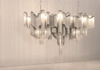 Against a warm plain backdrop, this lit silver Clérachic chandelier is shown with its tiers stepping outward.