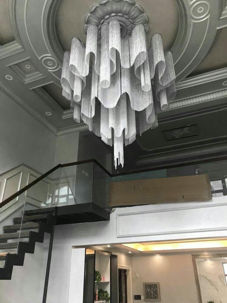 Beneath an ornate domed ceiling, this lit silver Clérachic chandelier hangs above a staircase.