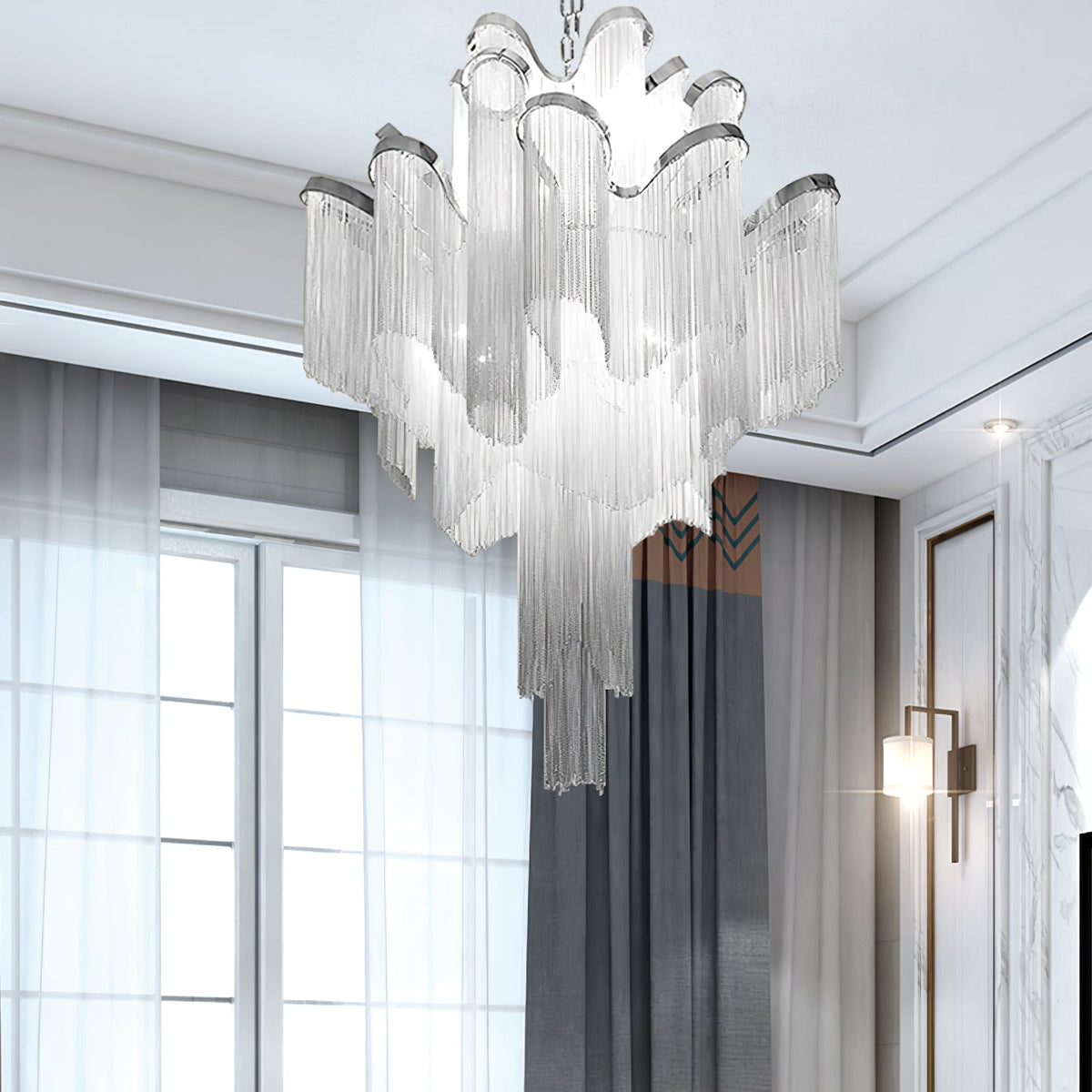 Sheer curtains and a panelled wooden door frame this lit silver Clérachic chandelier nearby.
