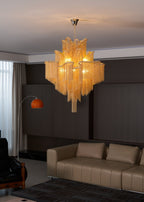 Cropped lower, this lit gold Clérachic chandelier hangs above a tan leather sofa in a dark-panelled lounge.