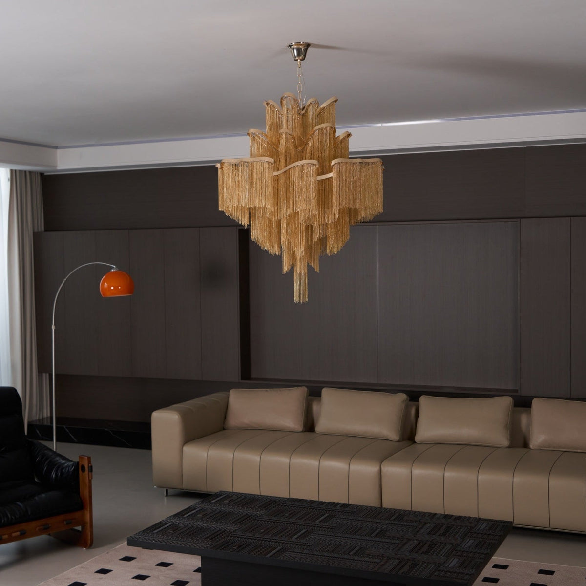 Seen slightly further back, this lit gold Clérachic chandelier hangs in the same dark-panelled lounge.