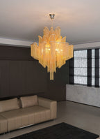 Above a tan leather sofa in a dark wood-panelled lounge, this lit gold Clérachic chandelier hangs overhead.