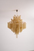 Seen from a different angle, this unlit gold Clérachic chandelier is shown against a white backdrop.