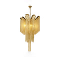 Trailing to a point, this lit gold Clérachic chandelier is shown against a white backdrop.