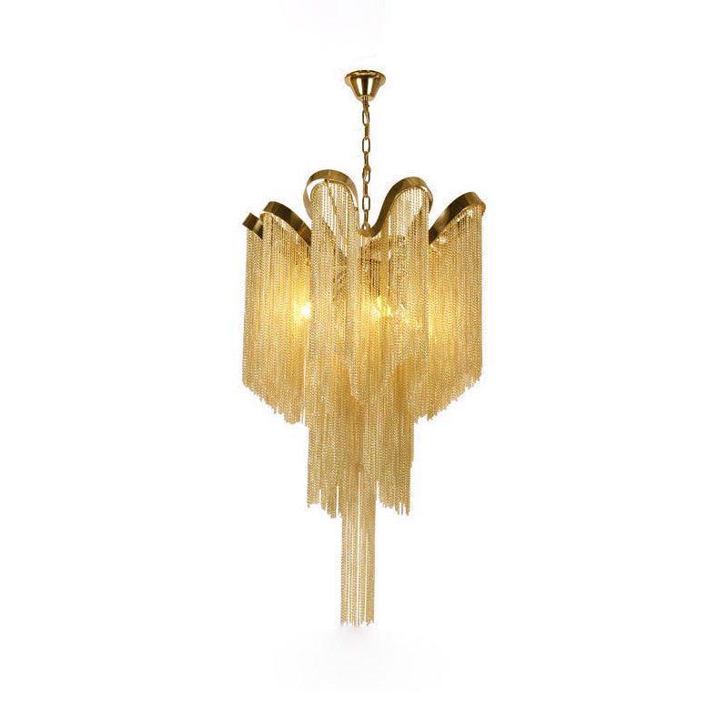 Trailing to a point, this lit gold Clérachic chandelier is shown against a white backdrop.