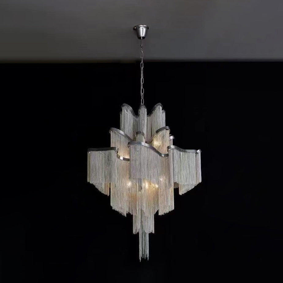 This silver Clérachic chandelier glows against a plain black backdrop, its chain fringe lit from within.