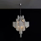 This silver Clérachic chandelier glows against a plain black backdrop, its chain fringe lit from within.