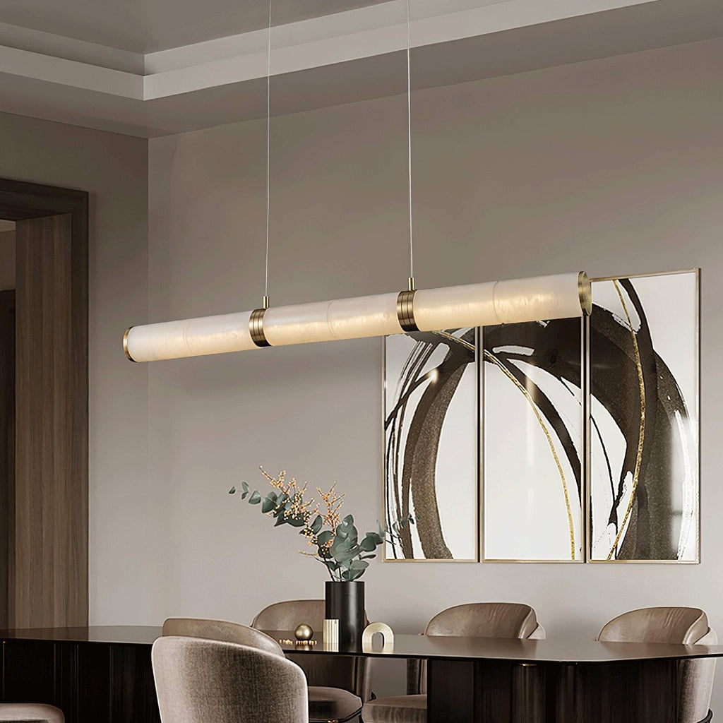 Stream pendant lit above a dark dining table, beside a triptych of circular brushstroke artwork.