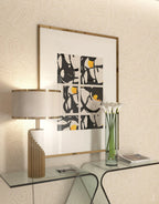 Near the same black-and-white print, a closer crop shows this Clérachic lamp's brass base beside a glass console vase.
