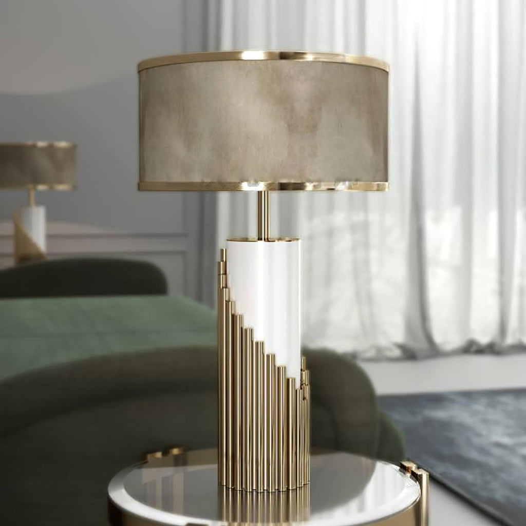 Beside a green sofa and sheer curtain, this Clérachic table lamp's gold ribbed base sits on a round mirrored side table.