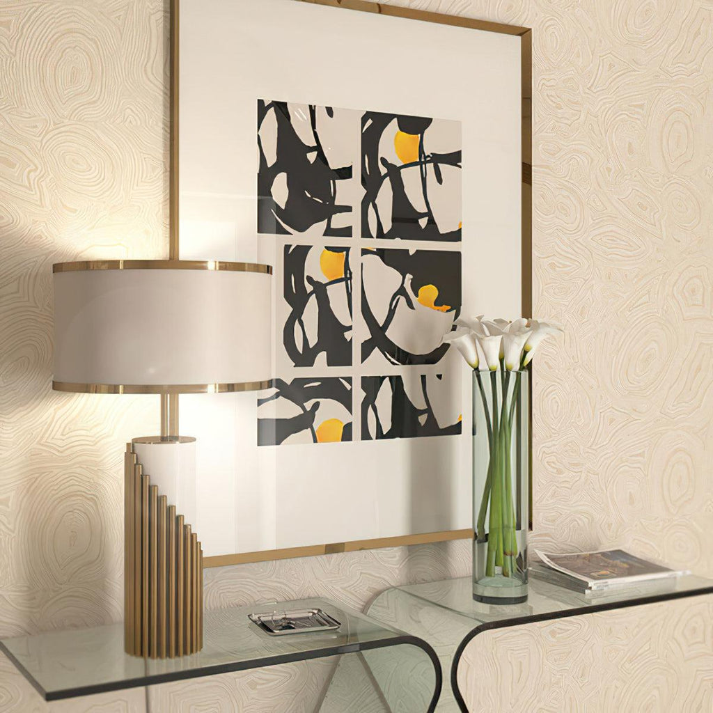 This Clérachic lamp sits on a glass console beside a black-and-white abstract print and a vase of white calla lilies.