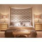 In this Clérachic bedroom scene, two stepped-base table lamps with pale pink shades flank a canopy bed on gold nightstands.