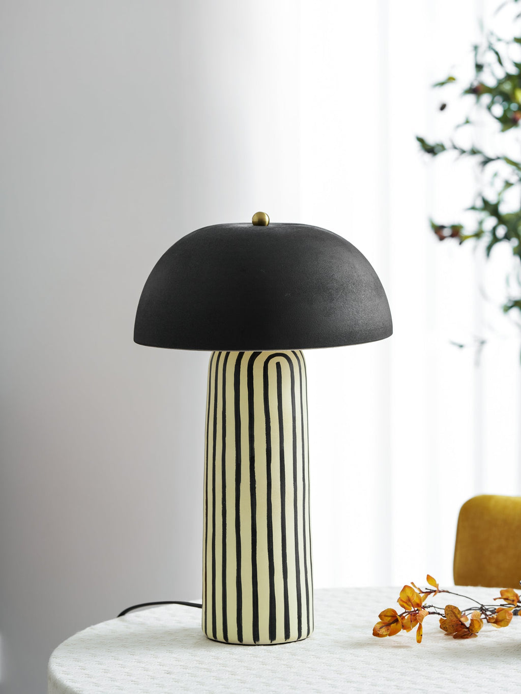 A sheer curtain and potted plant frame this Clérachic table lamp, styled on a round table by the window.