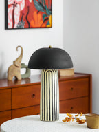 A small ceramic elephant figurine sits beside this Clérachic table lamp, a colourful painting above the dresser behind.