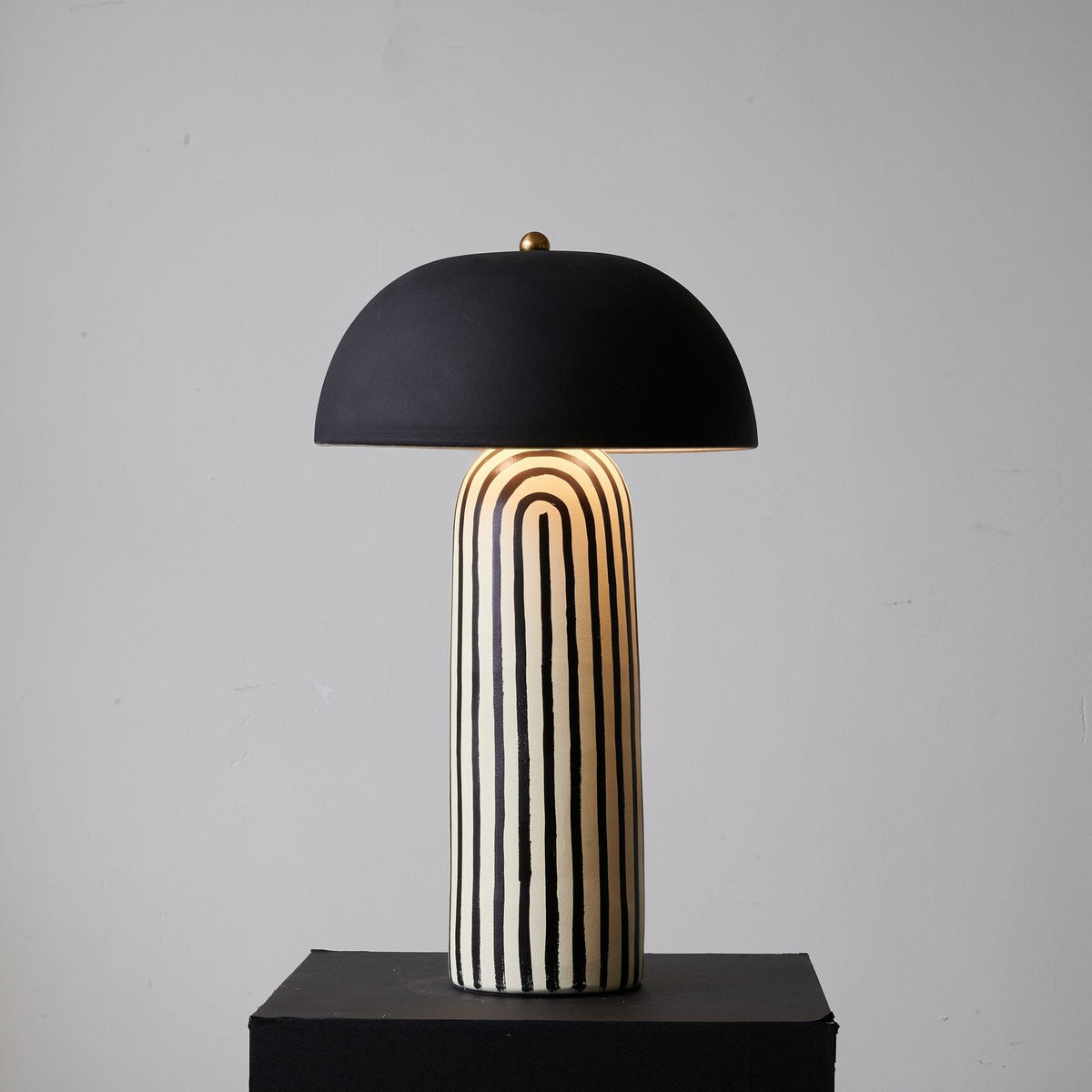 Rotated further on its black plinth, this Clérachic table lamp shows a different stretch of the ceramic base's striped pattern.