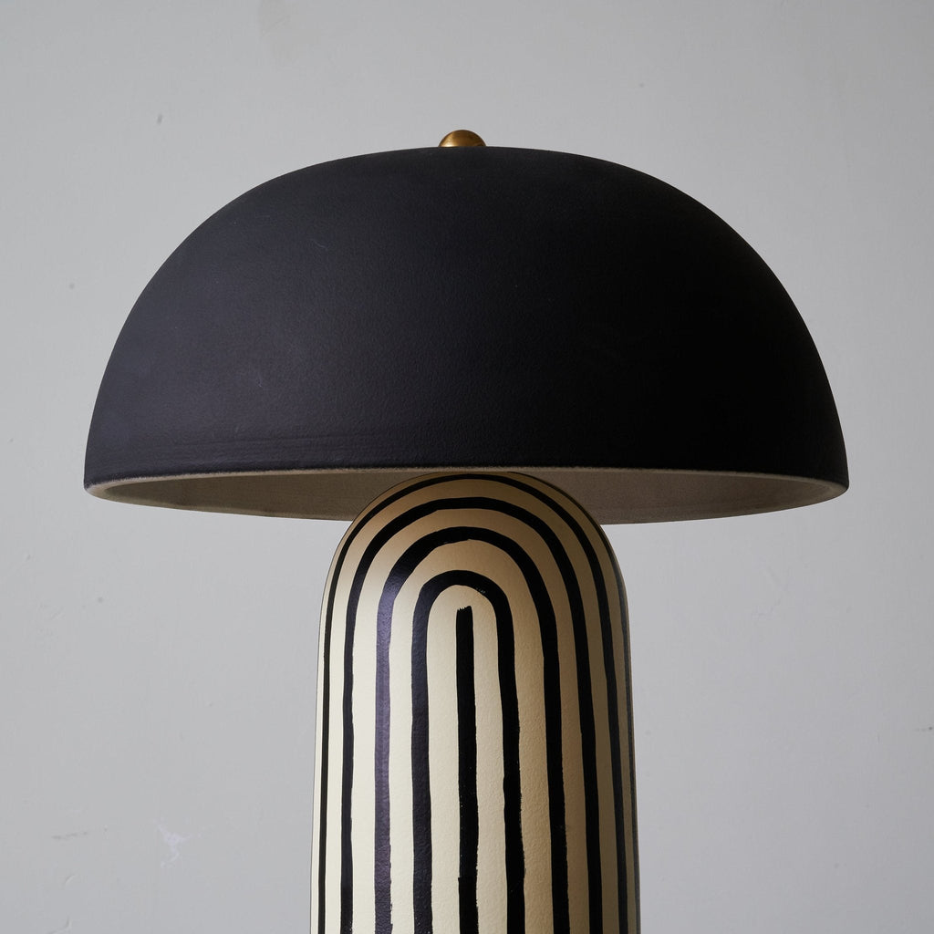A larger studio crop shows this Clérachic table lamp's matte black dome shade above the black-and-white striped base.