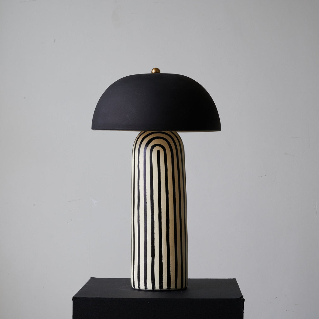 Seen from another angle on its black plinth, this Clérachic table lamp's black-and-white stripes wrap the rounded ceramic base.