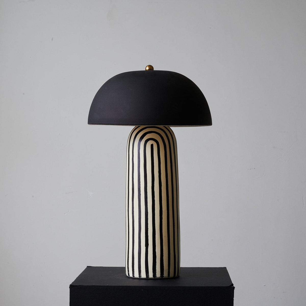 Seen from another angle on its black plinth, this Clérachic table lamp's black-and-white stripes wrap the rounded ceramic base.