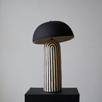 Centred on its black plinth, this Clérachic table lamp shows the dome shade above the vertically striped ceramic base.