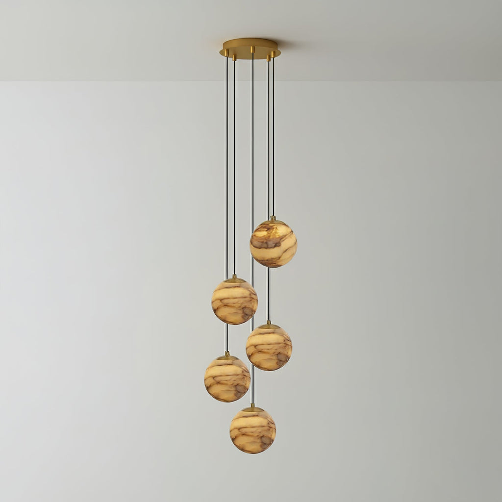 The five-light Sultana chandelier, five alabaster globes dropping at staggered lengths from a gold plate.