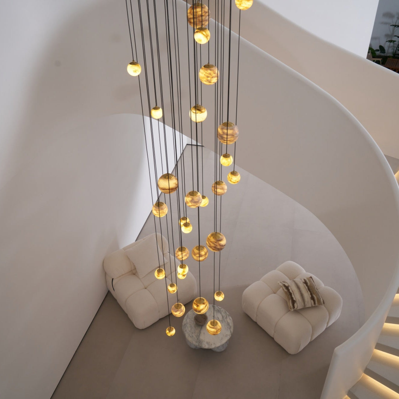 The Sultana chandelier seen from above, dropping through a curved stairwell to the lounge below.